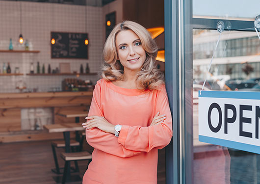 Business Owner Standing at Front Door Smiling with Business Insurance in Bossier City, Haughton, Mansfield, LA, Natchitoches, Shreveport, Vivian, LA